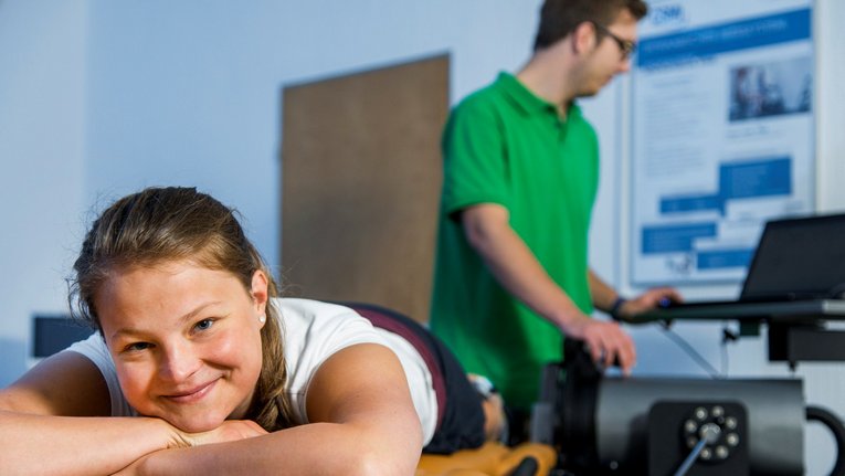 Person auf einer Liege vor einem Physiotherapeuten